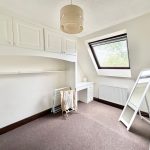 Small room with desk, mirror, and skylight.
