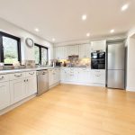 Modern kitchen with white cabinets and stainless steel appliances.