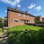 Red brick house with garden and blue sky