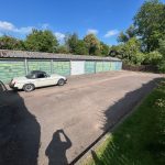 Classic car parked by blue garage doors.