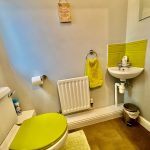 Small bathroom with green accents and sink.