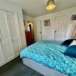 Cosy bedroom with blue bedding and wardrobe