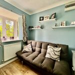 Cosy living room with sofa and family photos.