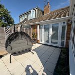 Patio with hanging chair and French doors.