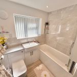 Modern bathroom with bathtub and sink.