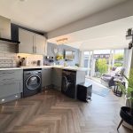 Modern kitchen with garden view and appliances.