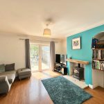 Cosy living room with large window and bookcase.
