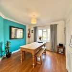 Bright dining room with wooden table and turquoise wall.