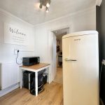 Kitchen corner with fridge and welcome sign.