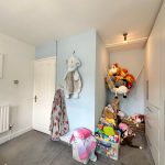 Children's bedroom with toys and blue wall.