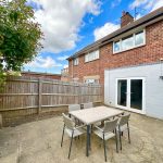 Brick house exterior with patio and garden furniture.