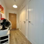 Hallway with wooden floor and closed doors.