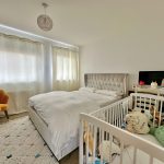 Cosy bedroom with cot and desk setup.