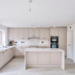 Modern white kitchen with island and cabinets.