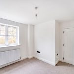 Empty white room with radiator and window
