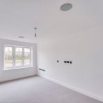 Empty bright room with large window and carpets.