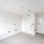 Empty white room with two closed doors