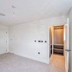 White room with closet and carpet flooring.