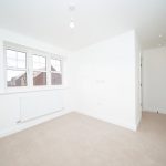 Empty bright room with window and radiator.