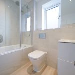 Modern bathroom with shower, toilet, and vanity unit.