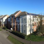 Modern apartment building with solar panels on roof.