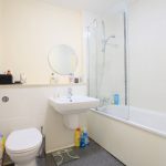 Modern bathroom with sink, toilet, and shower.