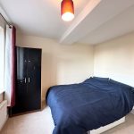 Bright bedroom with bed and wardrobe