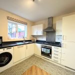 Modern kitchen with appliances and white cabinets.