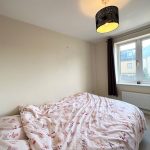 Cosy bedroom with double bed and window view.