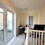Home office with desk and window view.