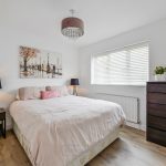 Modern bedroom with double bed and artwork.