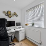 Modern home office with desk, chair, and computer.