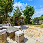 Spacious garden patio with seating and barbecue grill.