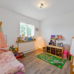 Children's playroom with toys and colourful bedding.