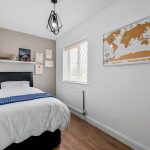 Small modern bedroom with map decoration.