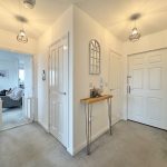 White hallway with modern lighting and doors