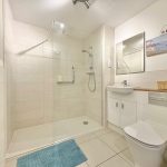 Modern bathroom with shower, sink, and toilet.