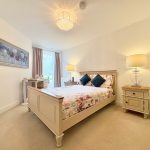 Bright bedroom with elegant decor and floral bedding.