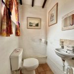 Small toilet with sink and art on wall