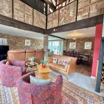 Spacious living room with rustic brick walls.