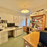 Cosy home office with desk and bookshelves.