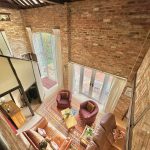 Loft living room with brick walls and large windows.
