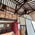 Modern rustic living area with exposed beams.