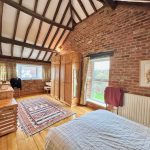 Rustic bedroom with wooden furniture and exposed brick walls.