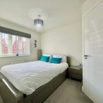 Modern bedroom with bed and window view.
