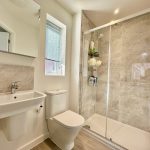 Modern bathroom with shower and sink.