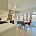 Modern kitchen with dining table and garden view.