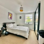 Bright bedroom with double bed and modern decor.