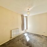 Empty room with beige walls and grey carpet