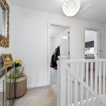 Stylish hallway with decorative mirror and flowers.